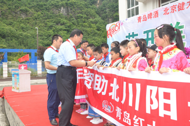 健力源集團工會副主席戰桂華給孩子們發放助學金